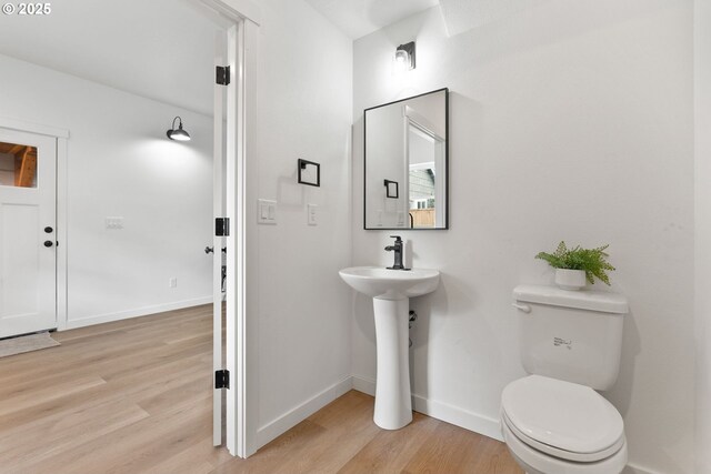 5712 SE Ramona St Unit C, Portland, OR 97206 - half bath featuring wood finished floors, baseboards, toilet, and a sink