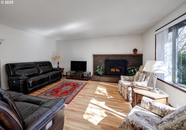 living area with a fireplace, wood finished floors, and a textured ceiling