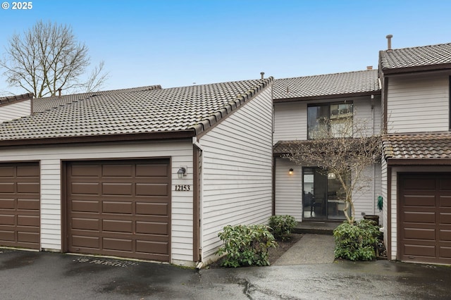 multi unit property with a garage and a tile roof