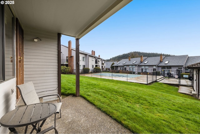 exterior space featuring a patio, a residential view, fence, and a community pool