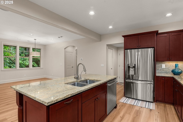 4661 Trillium, Woods, Lake Oswego, OR 97035 - kitchen featuring appliances with stainless steel finishes, arched walkways, light wood finished floors, tasteful backsplash, and recessed lighting