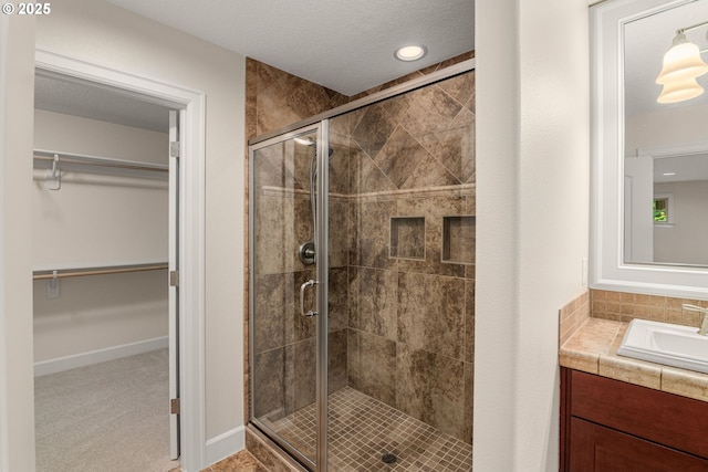 4661 Trillium, Woods, Lake Oswego, OR 97035 - bathroom featuring vanity, a stall shower, a walk in closet, and recessed lighting