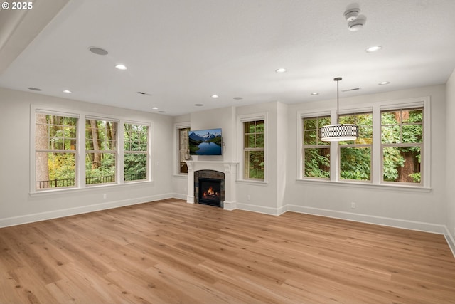 4661 Trillium, Woods, Lake Oswego, OR 97035 - unfurnished living room with plenty of natural light, light wood-style flooring, a warm lit fireplace, and recessed lighting
