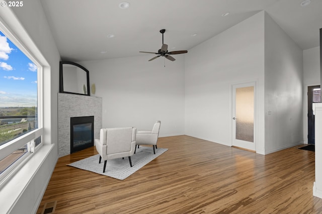 175 Truman Dr, Umatilla, OR 97882 - sitting room featuring a stone fireplace, visible vents, ceiling fan, high vaulted ceiling, and wood finished floors