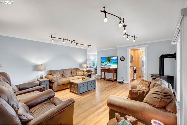6836 NW Bony Rd, Yamhill, OR 97148 - living room featuring track lighting, ornamental molding, light wood-style floors, a wood stove, and baseboards