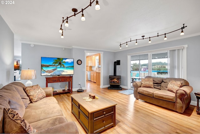 6836 NW Bony Rd, Yamhill, OR 97148 - living area featuring a wood stove, rail lighting, light wood finished floors, crown molding, and baseboards
