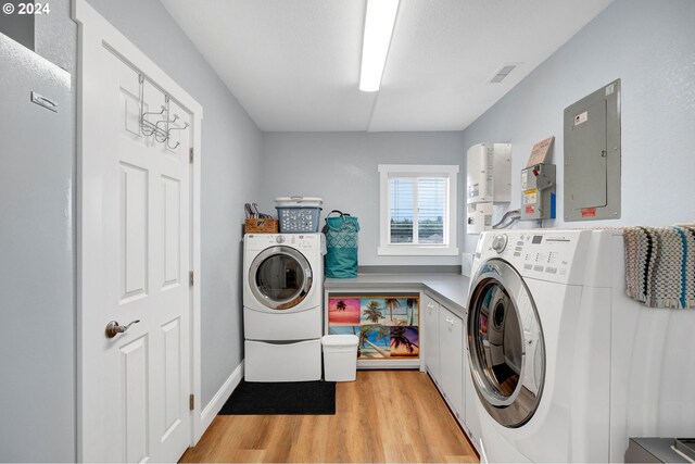 6836 NW Bony Rd, Yamhill, OR 97148 - washroom with electric panel, independent washer and dryer, cabinet space, and light wood-type flooring