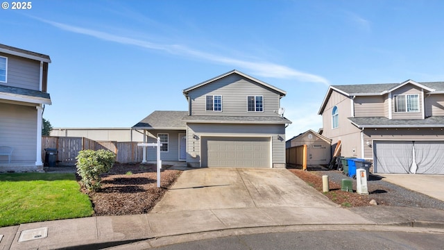 traditional-style home featuring concrete driveway, fence, and an attached garage