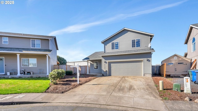 traditional home featuring an attached garage, fence, a front lawn, and concrete driveway