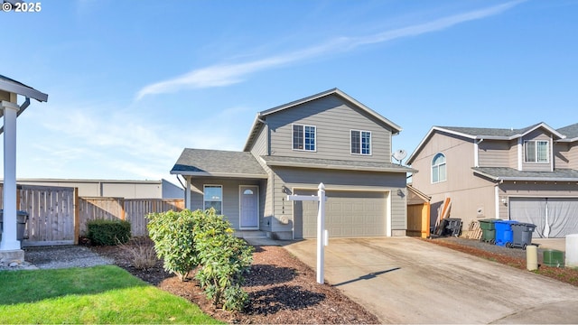 traditional home with a garage, fence, and concrete driveway