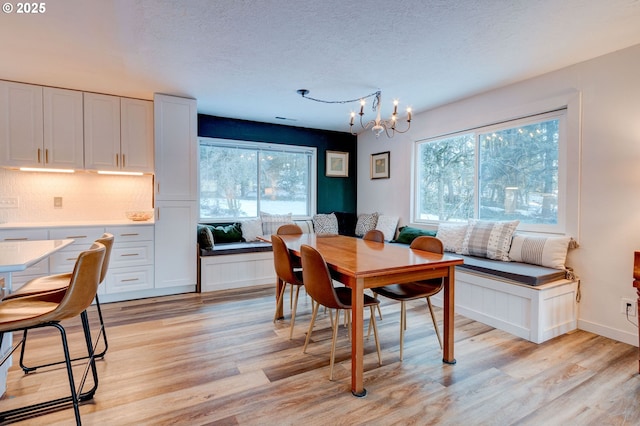 24492 SE Three Cedars St, Damascus, OR 97089 - dining space with light wood-style floors, a chandelier, and a textured ceiling