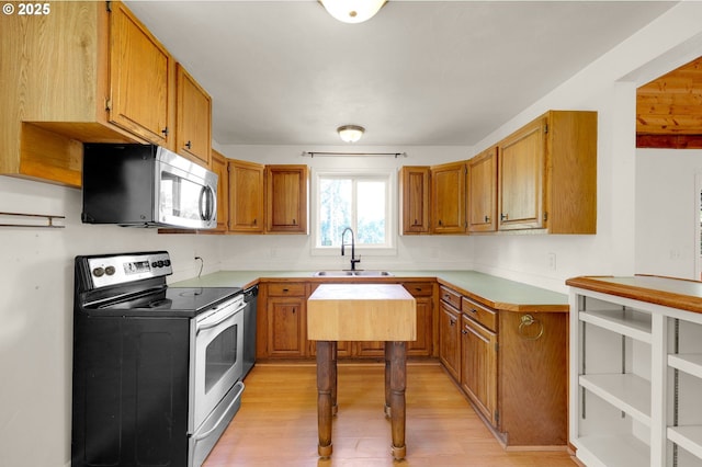 8157 S A St, Springfield, OR 97478 - kitchen featuring appliances with stainless steel finishes, light wood-type flooring, brown cabinetry, and light countertops