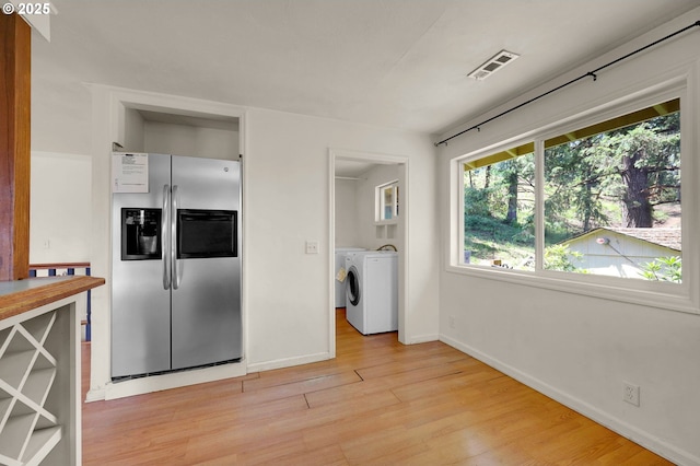 8157 S A St, Springfield, OR 97478 - kitchen featuring stainless steel fridge with ice dispenser, washing machine and clothes dryer, and light wood-type flooring