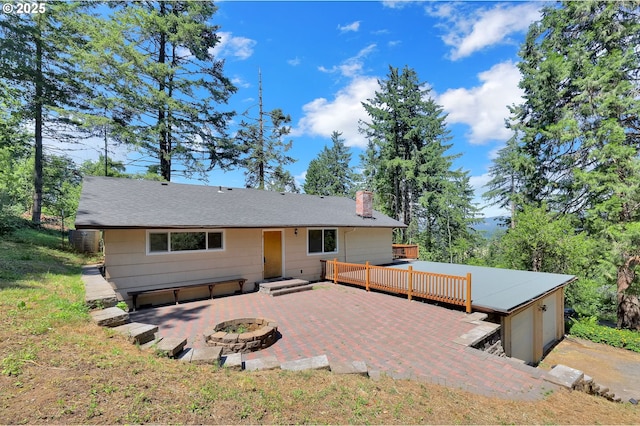 8157 S A St, Springfield, OR 97478 - view of front of home with an outdoor fire pit, a chimney, a wooden deck, and a patio area
