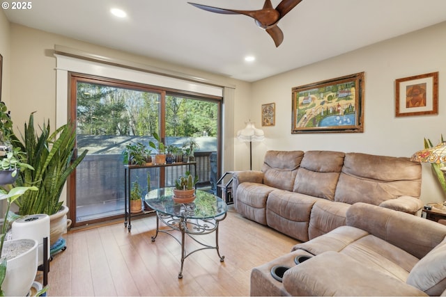 living room featuring light hardwood / wood-style flooring and ceiling fan