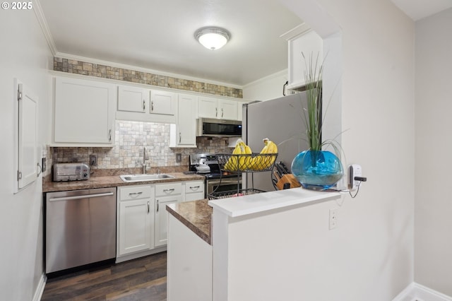 kitchen with sink, tasteful backsplash, appliances with stainless steel finishes, kitchen peninsula, and white cabinets