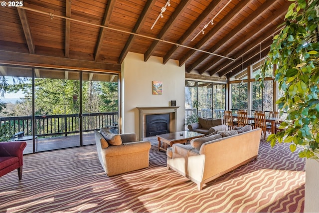 sunroom / solarium featuring vaulted ceiling with beams, track lighting, and wooden ceiling