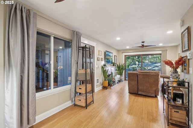 foyer featuring light wood finished floors, a ceiling fan, and baseboards