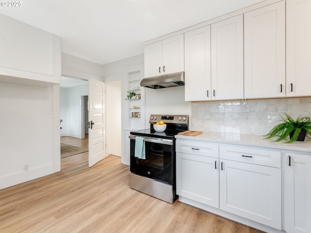 kitchen with electric stove, backsplash, white cabinetry, and light wood-type flooring