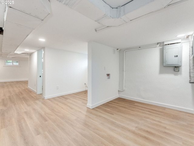 basement with electric panel and light wood-type flooring