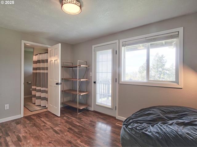 bedroom with baseboards, dark wood-style flooring, and a textured ceiling