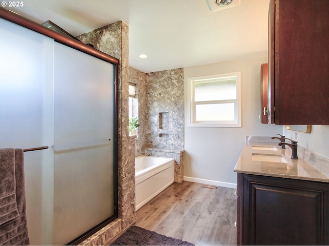full bathroom with plenty of natural light, wood finished floors, a bath, and a shower stall