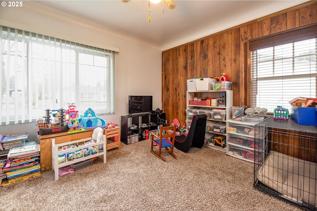 game room featuring plenty of natural light, carpet flooring, and wood walls