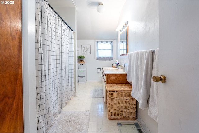 bathroom featuring vanity, lofted ceiling, and walk in shower