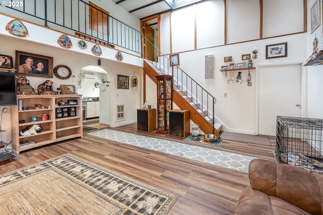 living room featuring hardwood / wood-style flooring and a towering ceiling