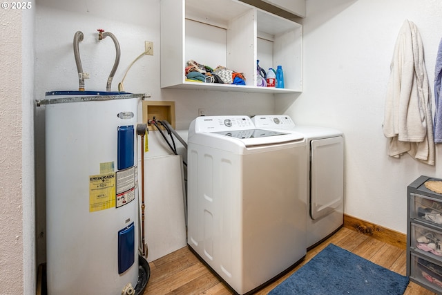 washroom with washer and dryer, water heater, and light wood-type flooring