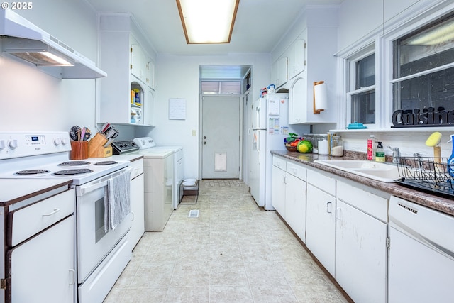 kitchen with independent washer and dryer, sink, white cabinets, and white appliances