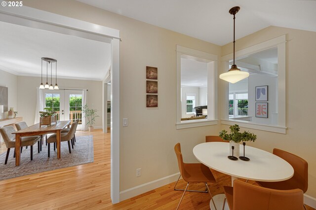 dining room with light wood-type flooring, healthy amount of natural light, french doors, and baseboards