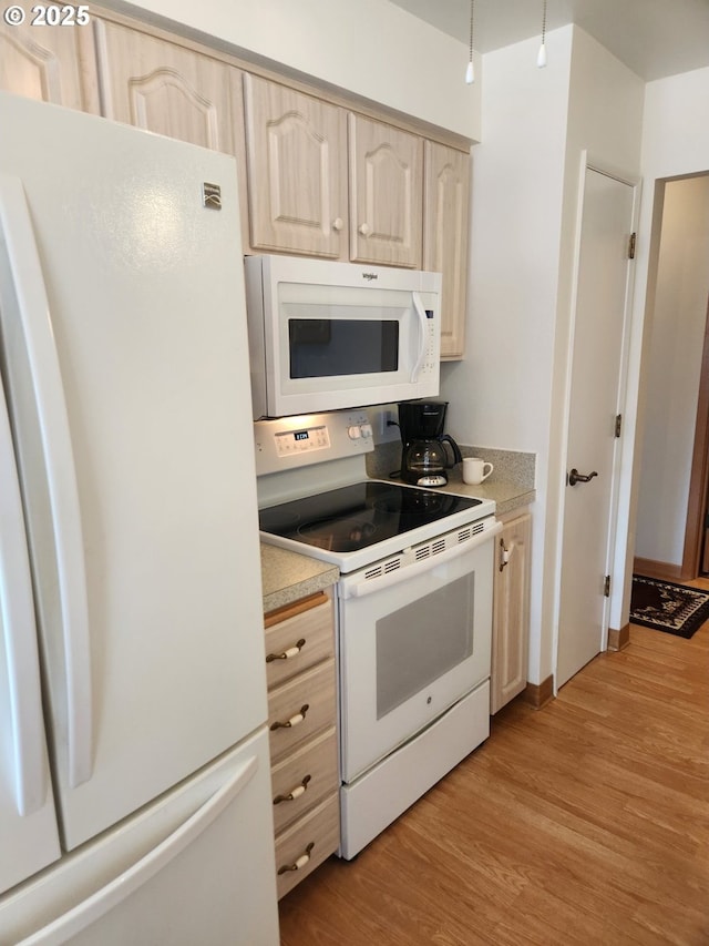 kitchen with light countertops, white appliances, light brown cabinets, and light wood-style floors