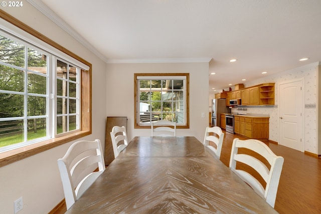 dining space featuring a healthy amount of sunlight, dark hardwood / wood-style floors, and ornamental molding