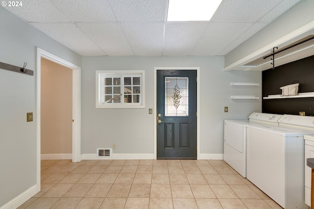 clothes washing area featuring washer and clothes dryer and light tile patterned floors