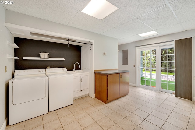 clothes washing area with cabinets, electric panel, washer and clothes dryer, and light tile patterned flooring