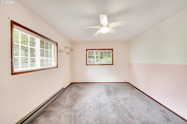 carpeted empty room featuring baseboard heating, a healthy amount of sunlight, and ceiling fan