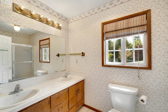 bathroom featuring tile patterned floors, vanity, toilet, and an enclosed shower