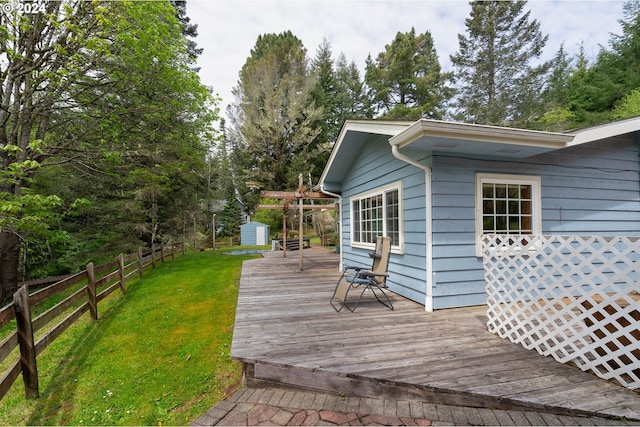 deck featuring a storage shed and a lawn