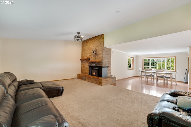 carpeted living room featuring a fireplace and a notable chandelier