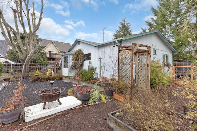 rear view of property featuring an outdoor fire pit and an outdoor structure