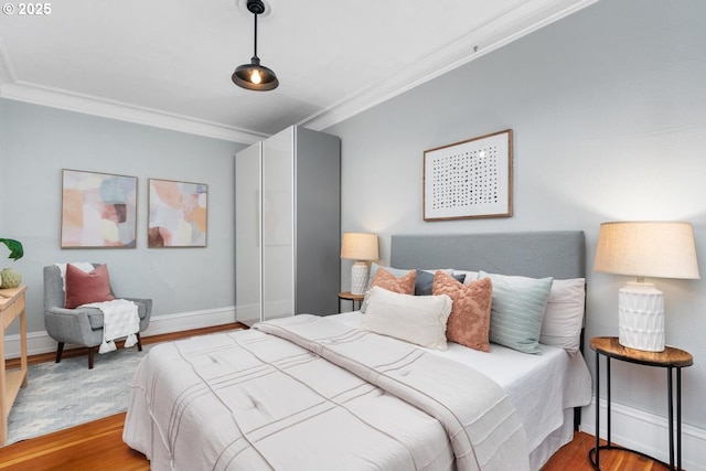 bedroom featuring ornamental molding and light hardwood / wood-style floors