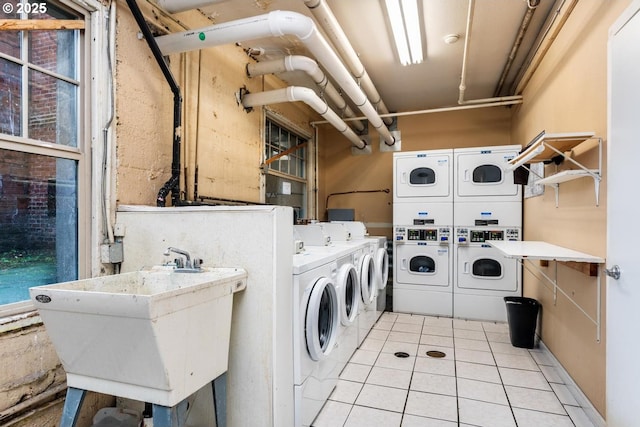 laundry room featuring sink, light tile patterned floors, washing machine and clothes dryer, and stacked washer / dryer