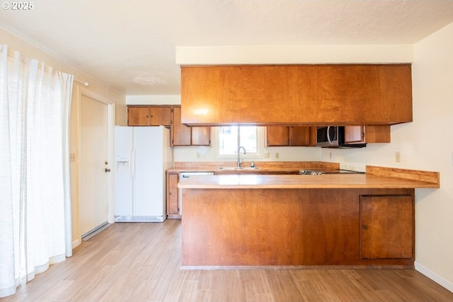 4631 Daisy St, Springfield, OR 97478 - kitchen featuring white fridge with ice dispenser, brown cabinets, light wood-style flooring, a peninsula, and light countertops