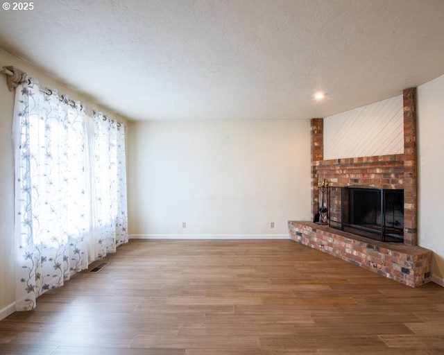 4631 Daisy St, Springfield, OR 97478 - unfurnished living room featuring a brick fireplace, wood finished floors, a textured ceiling, and recessed lighting