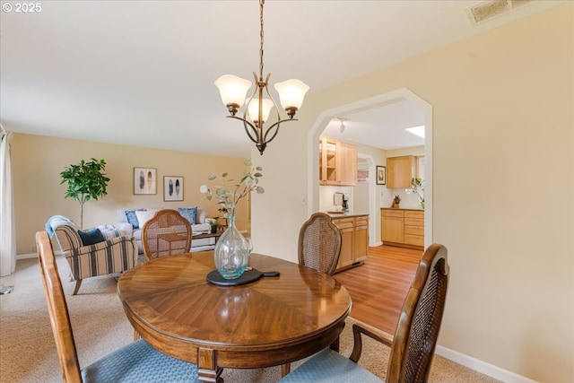 8740 SW Bomar Ct, Portland, OR 97223 - dining area with a chandelier, baseboards, arched walkways, and light colored carpet