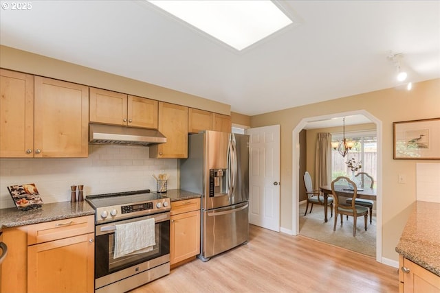 8740 SW Bomar Ct, Portland, OR 97223 - kitchen featuring under cabinet range hood, appliances with stainless steel finishes, arched walkways, light brown cabinetry, and decorative backsplash