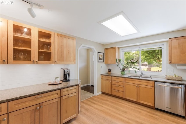 8740 SW Bomar Ct, Portland, OR 97223 - kitchen with stainless steel dishwasher, a sink, light wood-type flooring, arched walkways, and backsplash