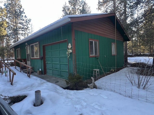 view of snowy exterior featuring a garage