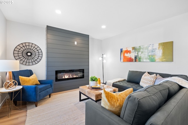 living room with a fireplace, recessed lighting, and wood finished floors